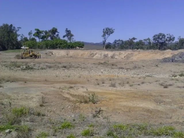 Land With Excavator Two Yellow Big Excavator In The Dirty Field — Mike Barlow Earthmoving Pty Ltd in Rockhampton, QLD