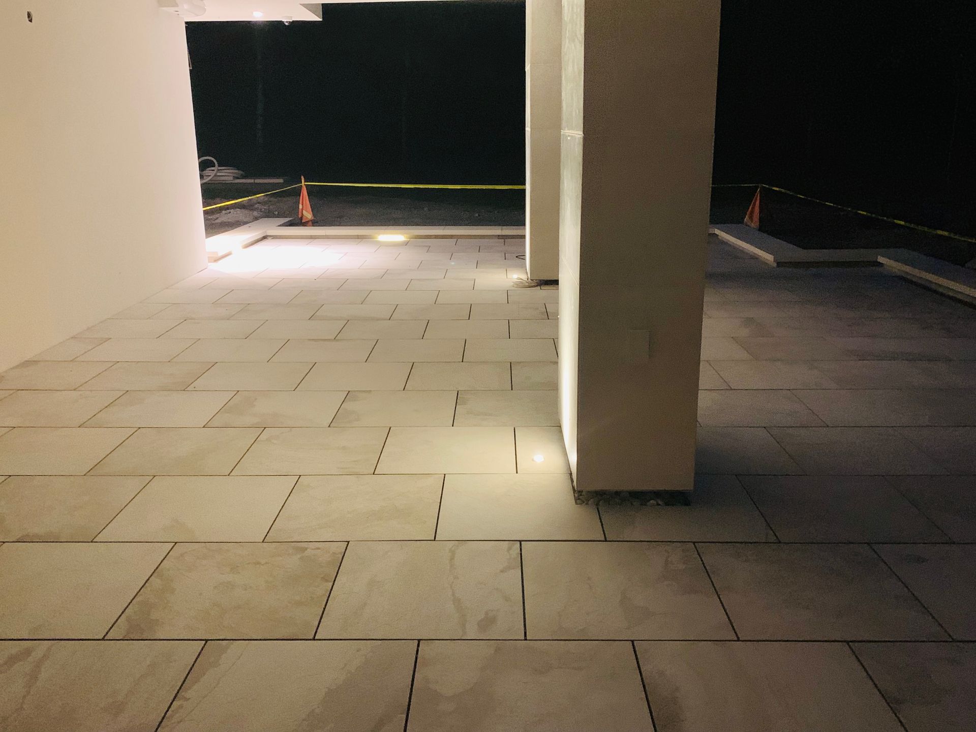 Patio couvert vide avec sol carrelé et piliers carrés la nuit