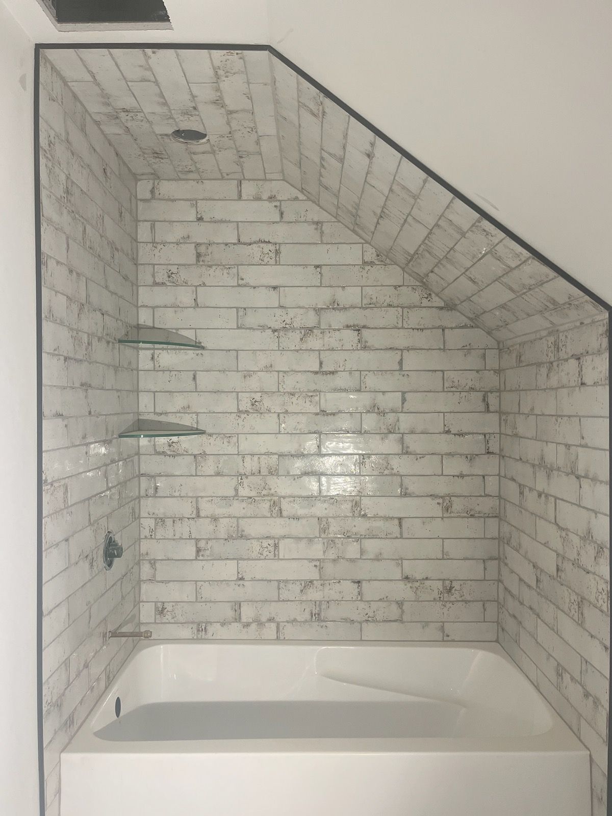 A bathroom with a brick wall and a bathtub