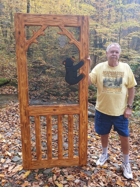 David DJ Jones in a yellow shirt is standing next to a custom screen door