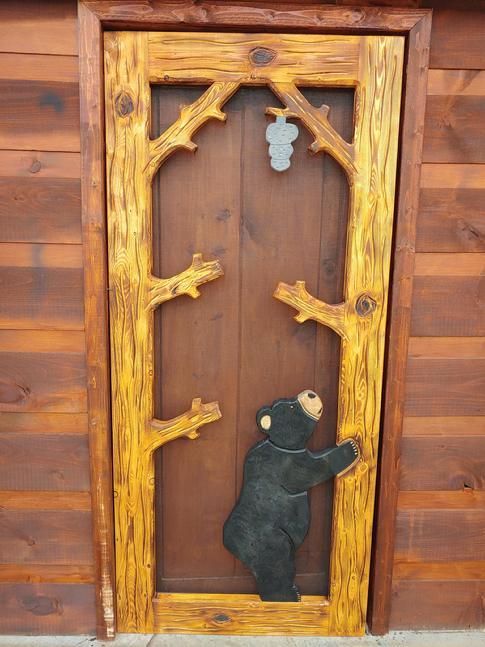 Carved Door showing Bear Looking at Beehive 