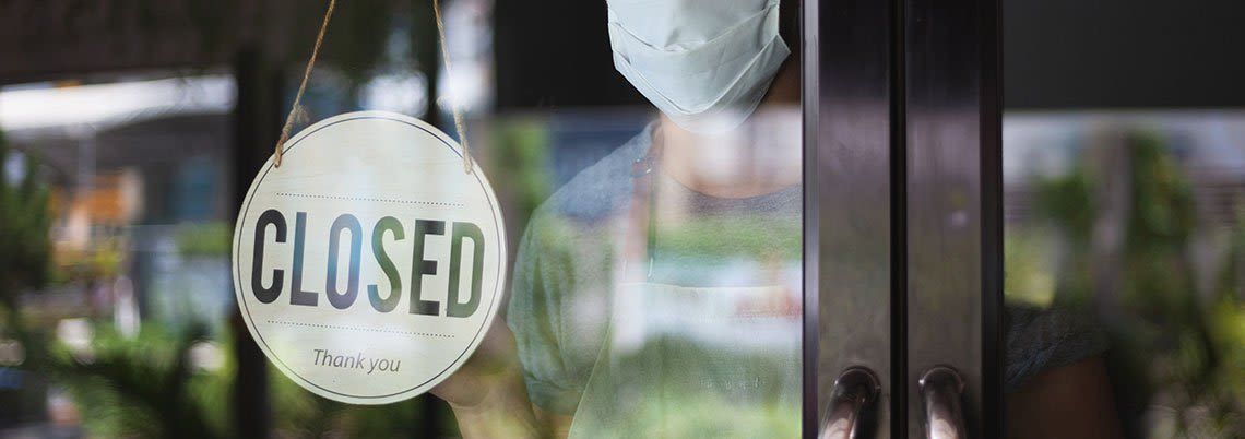 A closed sign is hanging on a glass door. A closed sign is hanging on a glass door.
