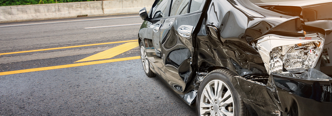 A black car with a damaged side is parked on the side of the road. A black car with a damaged side is parked on the side of the road.