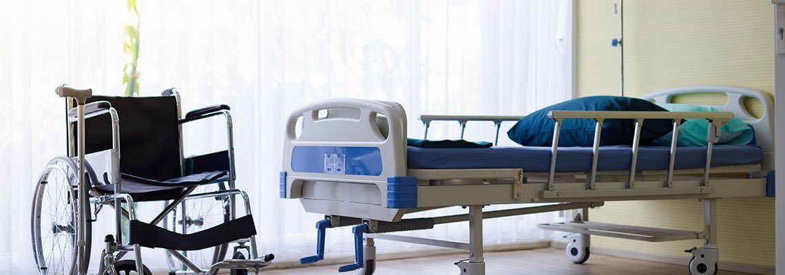 There is a wheelchair and a hospital bed in the room.