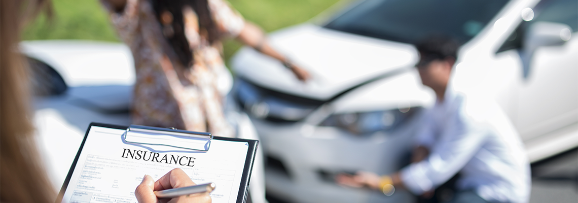 A woman is writing on a clipboard in front of a car accident. A woman is writing on a clipboard in front of a car accident.
