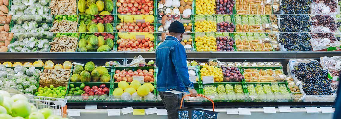 A man is shopping for fruits and vegetables in a grocery store. A man is shopping for fruits and vegetables in a grocery store.