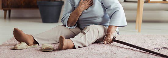 An elderly woman is sitting on the floor with a cane. An elderly woman is sitting on the floor with a cane.
