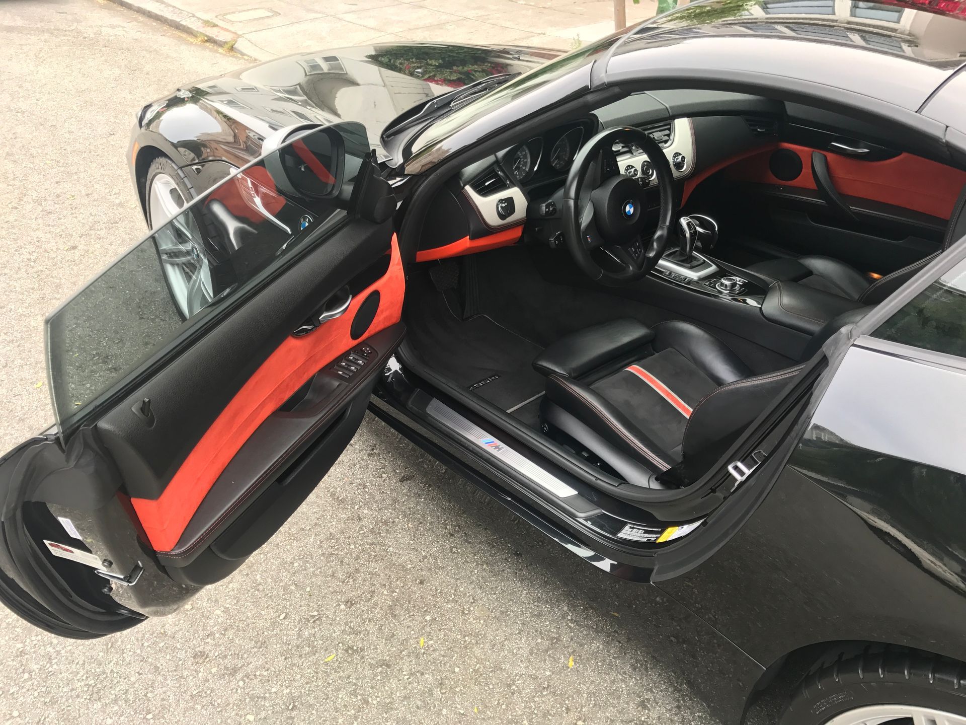 The inside of a black car with the door open.