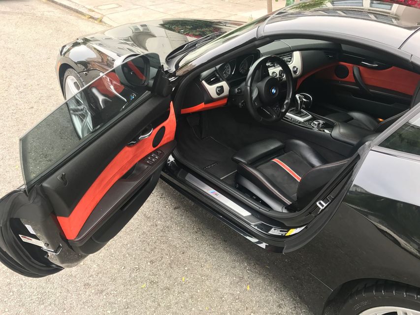 The inside of a black car with the door open.