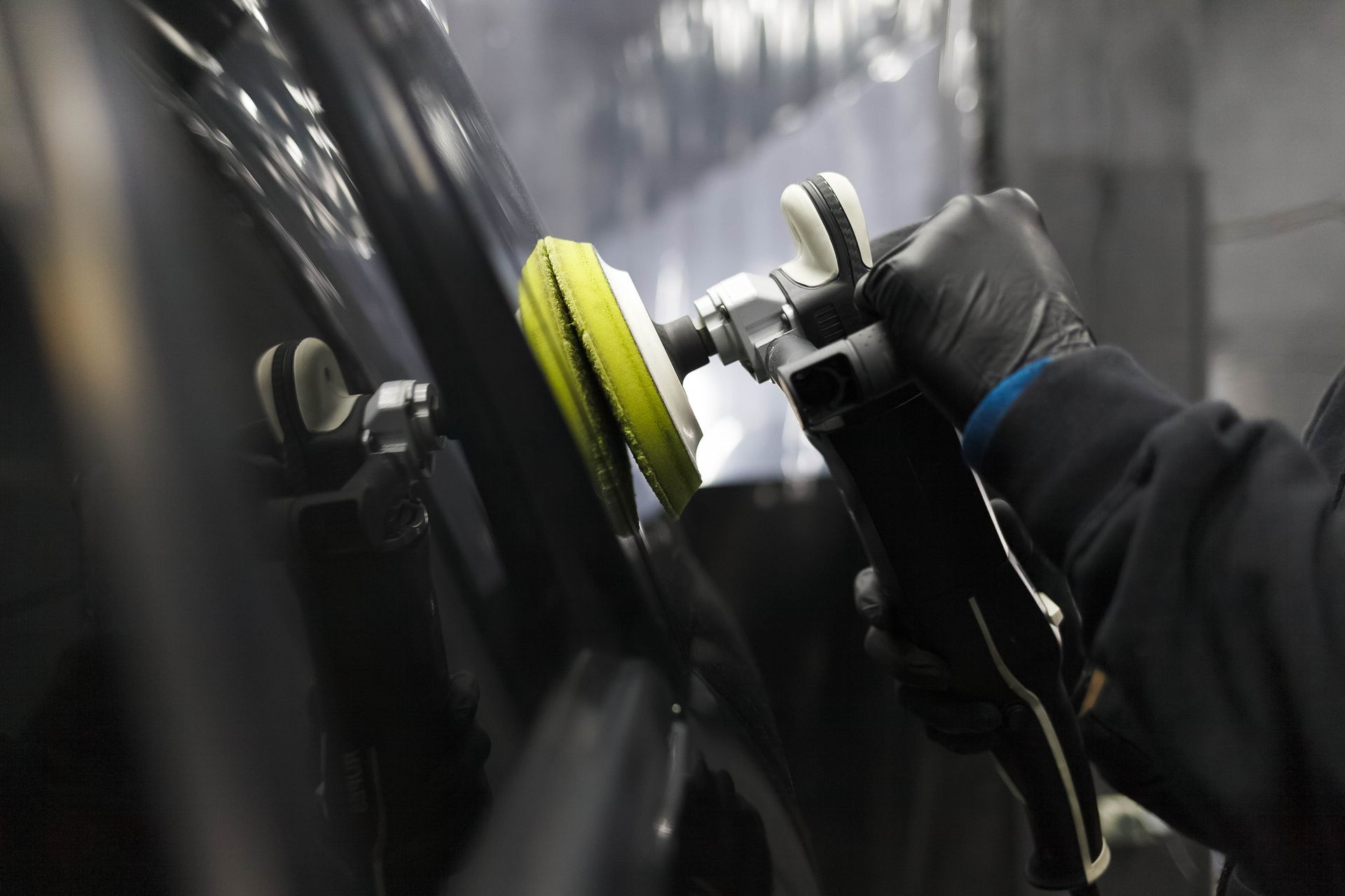 A person is polishing a car with a polisher.
