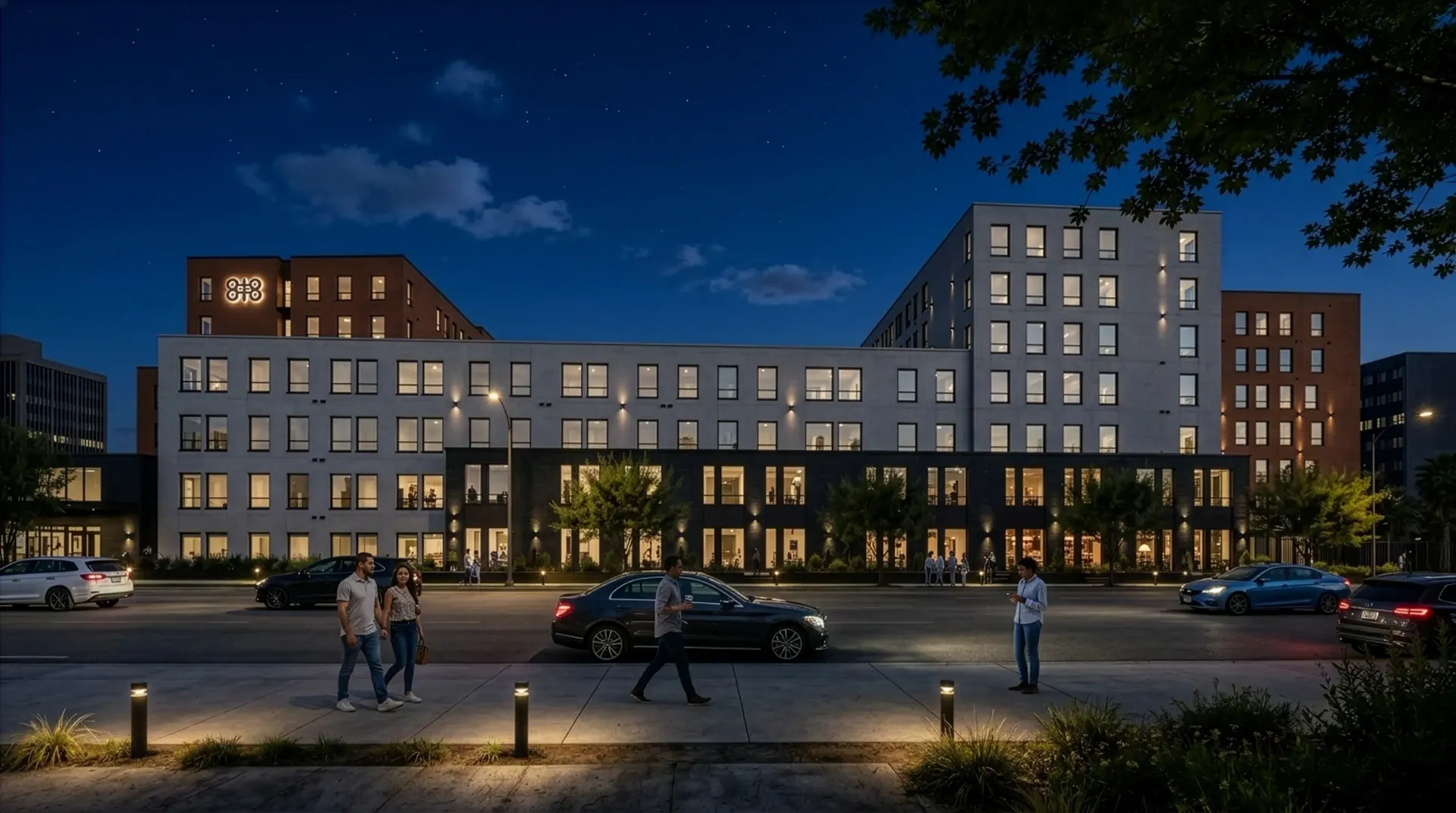 Exterior of a modern apartment building at dusk with people walking on the sidewalk.