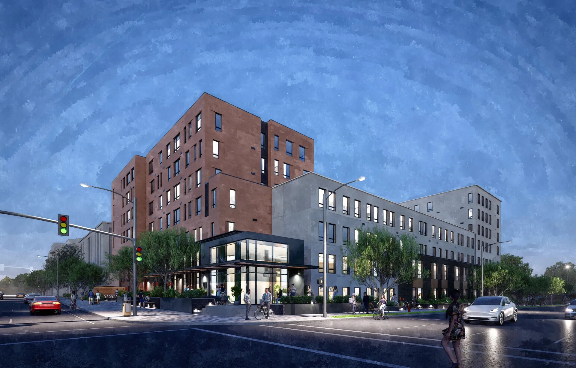 Modern apartment building exterior at dusk with illuminated windows, streetlights, and a glass-enclosed entrance.