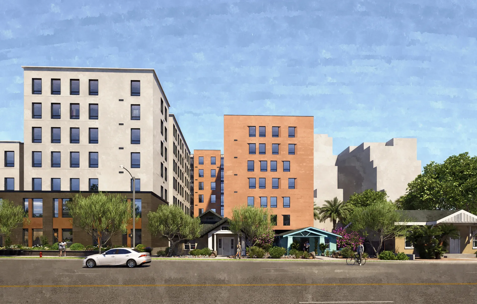 Exterior view of a multifamily property showing multiple buildings of varying heights and colors, with landscaping and a street in the foreground.