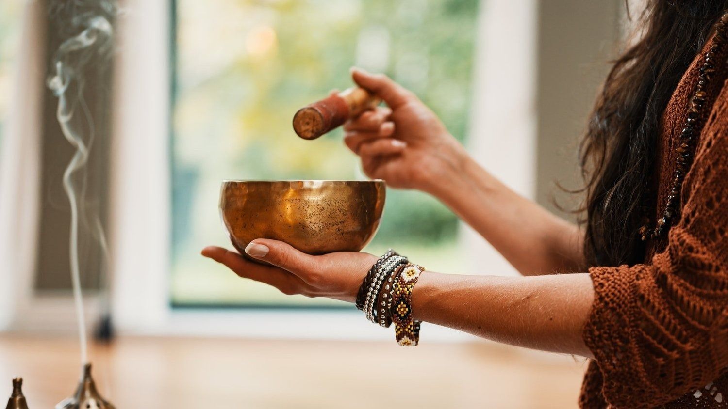 A Woman Is Holding A Singing Bowl In Her Hands — The Enchanted Wolf Holistic Port Macquarie, NSW