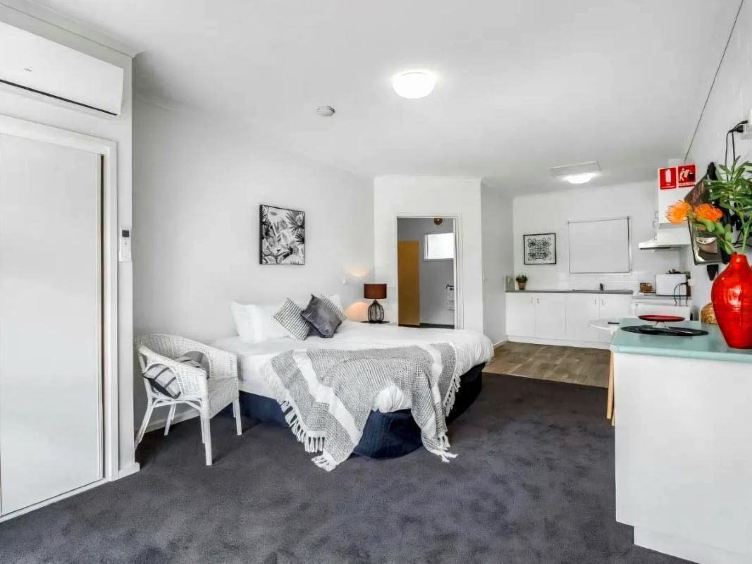 Accessible studio apartment at Admiral Place Geelong featuring a step-free walk-in shower and shower chair