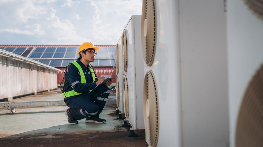 Technician performing commercial HVAC maintenance checklist inspection