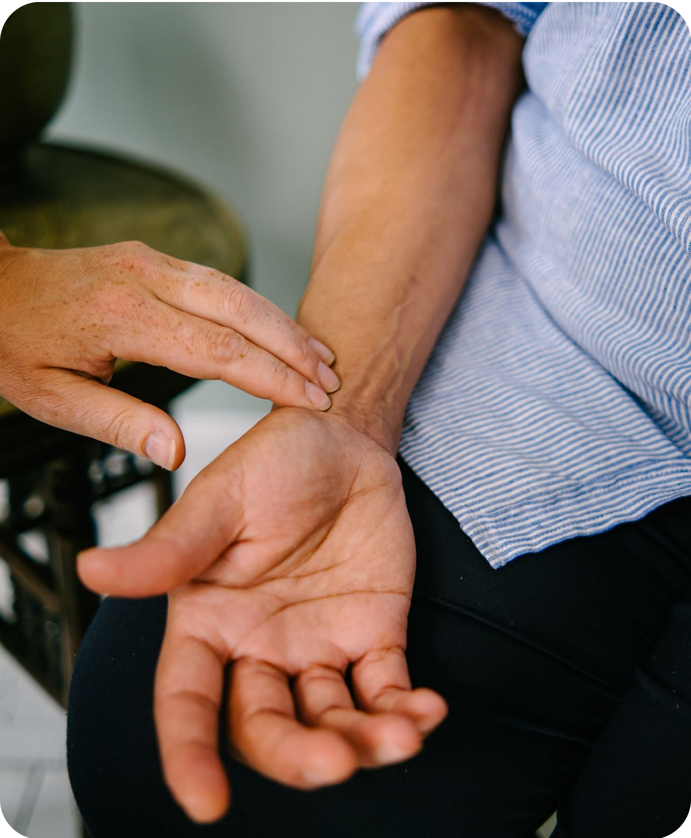 A close-up of an acupuncturist reading a patient's pulse who is lying down. It's a key diagnostic pillars of acupuncture.