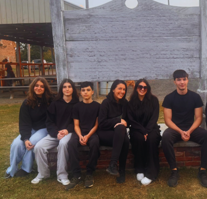 A group of people sitting in front of a sign
