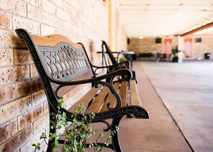 Black metal bench along a brick wall on a covered outdoor walkway