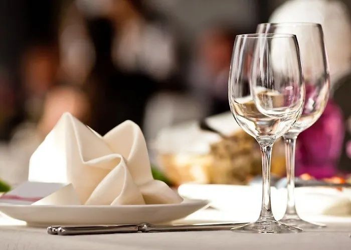 Elegant restaurant table setting with folded napkins, wine glasses, and soft blurred background lighting