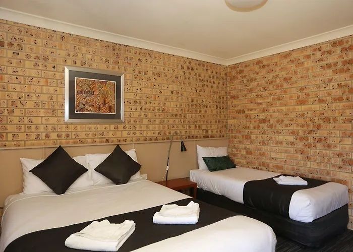 Hotel room with two neatly made single beds, white linens, black accents, and patterned wallpaper Hotel room with two neatly made single beds, white linens, black accents, and patterned wallpaper
