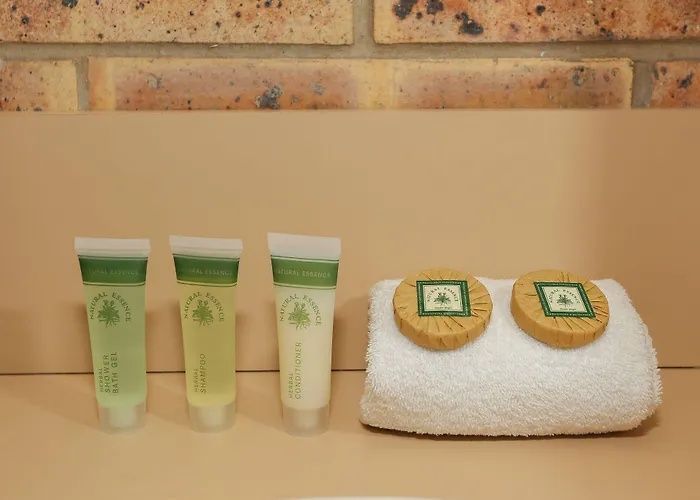 Spa toiletries and soaps on a folded white towel against a brick wall