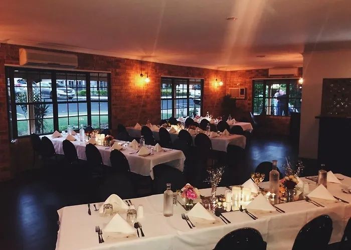Dimly lit banquet hall with white-clothed tables set for a formal dinner event