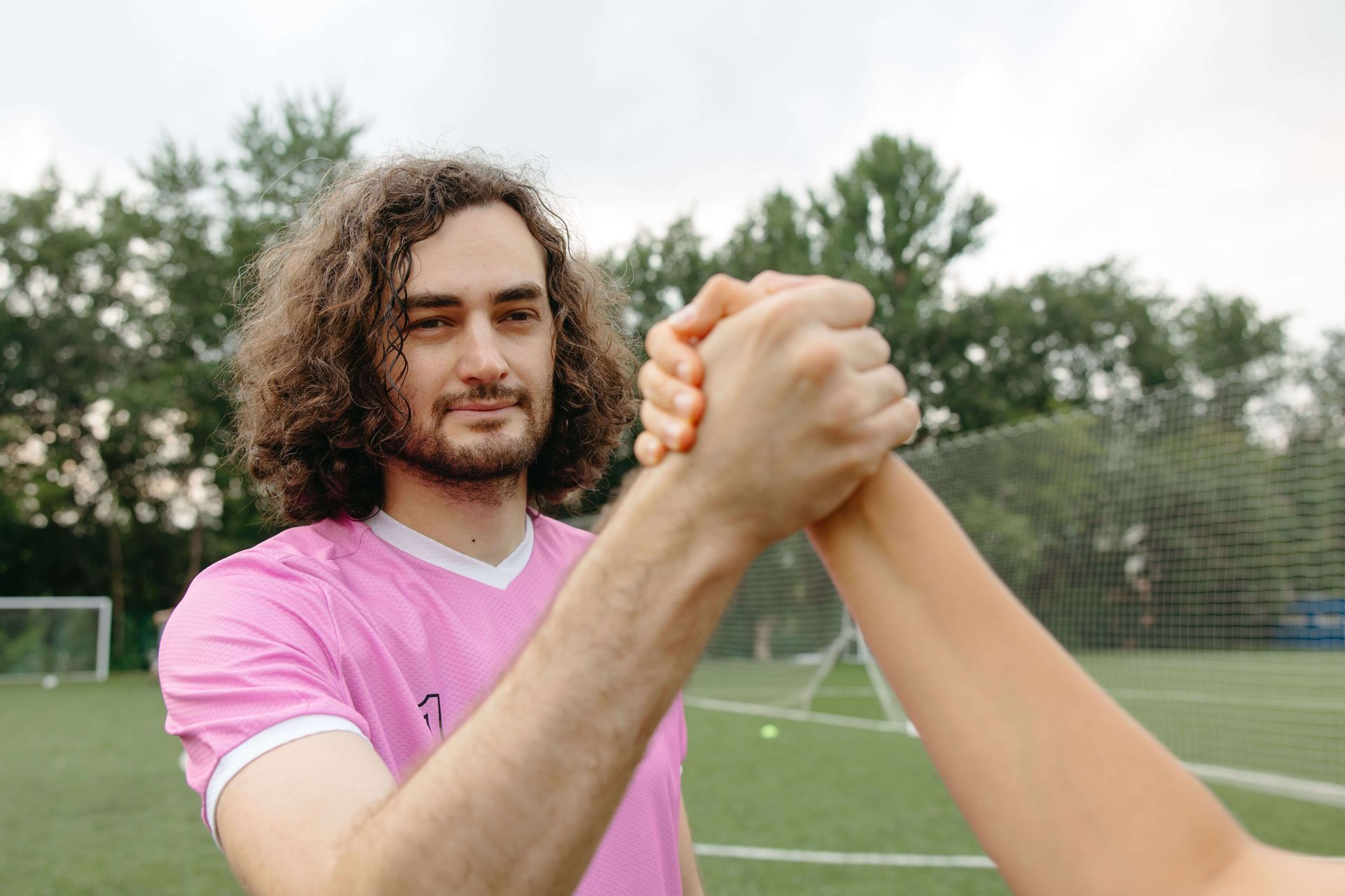 Soccer player grasping hands with a teammate. Grief therapy for athletes in Omaha, NE, can help.