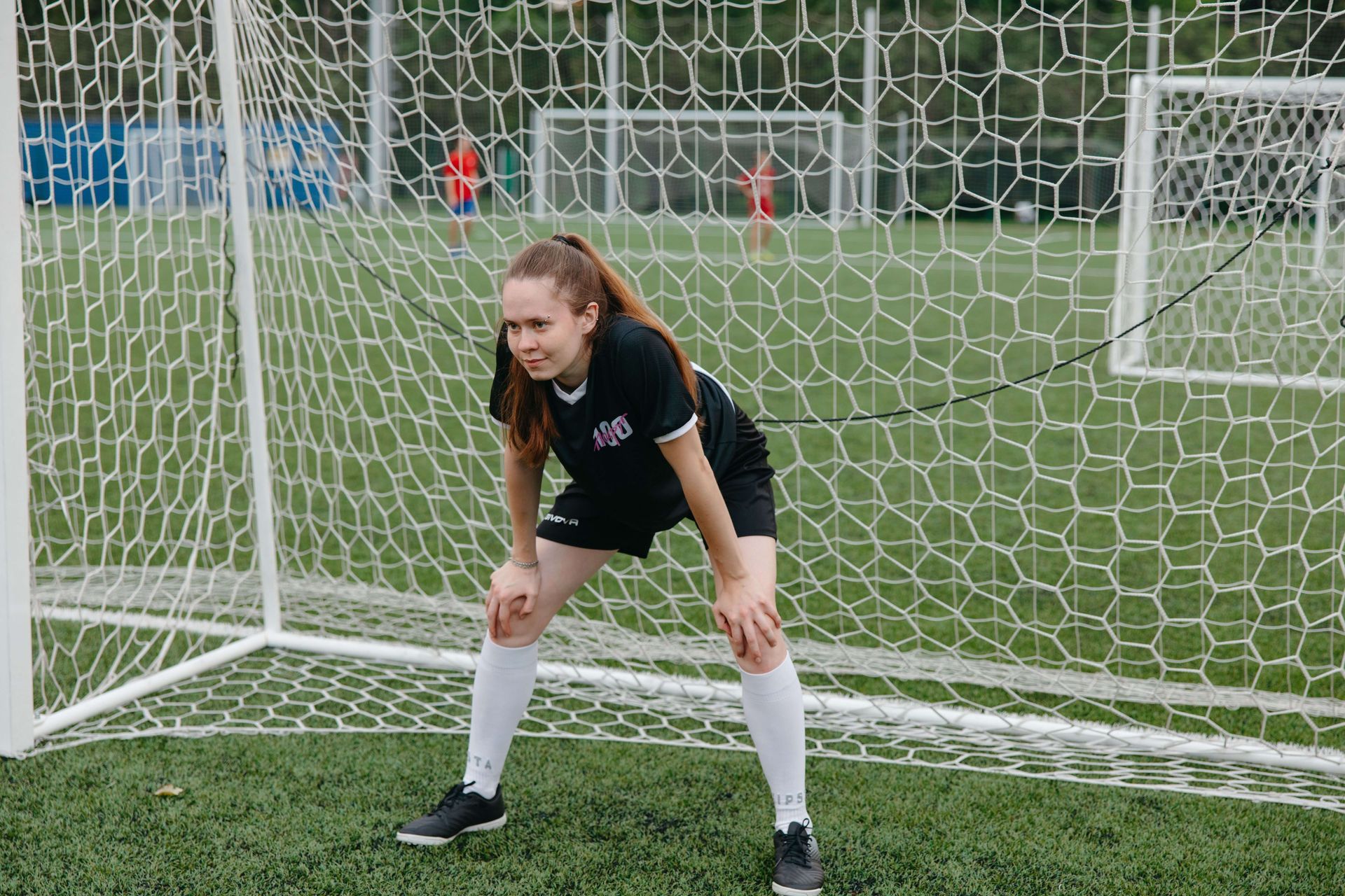 Woman goalie standing in front of a soccer net looking anxious. Anxiety therapy in Omaha can help.