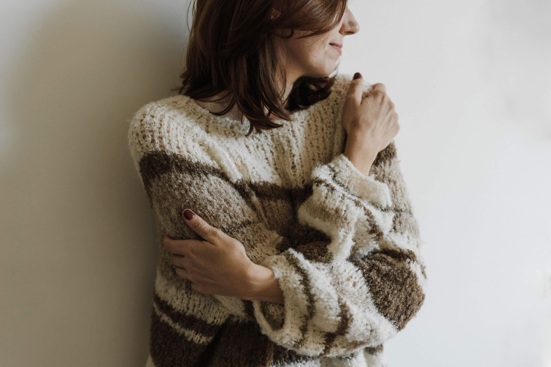 Close-up of a woman hugging herself while wearing a sweater, representing self-compassion, emotional regulation, and calming anxiety responses through EMDR therapy for anxiety in Omaha, NE | emdr therapy for anxiety omaha ne - anxiety therapy omaha ne - anxiety counseling omaha ne - elkhorn - gretna - bennington - blair - millard - wahoo - waverly - papillion