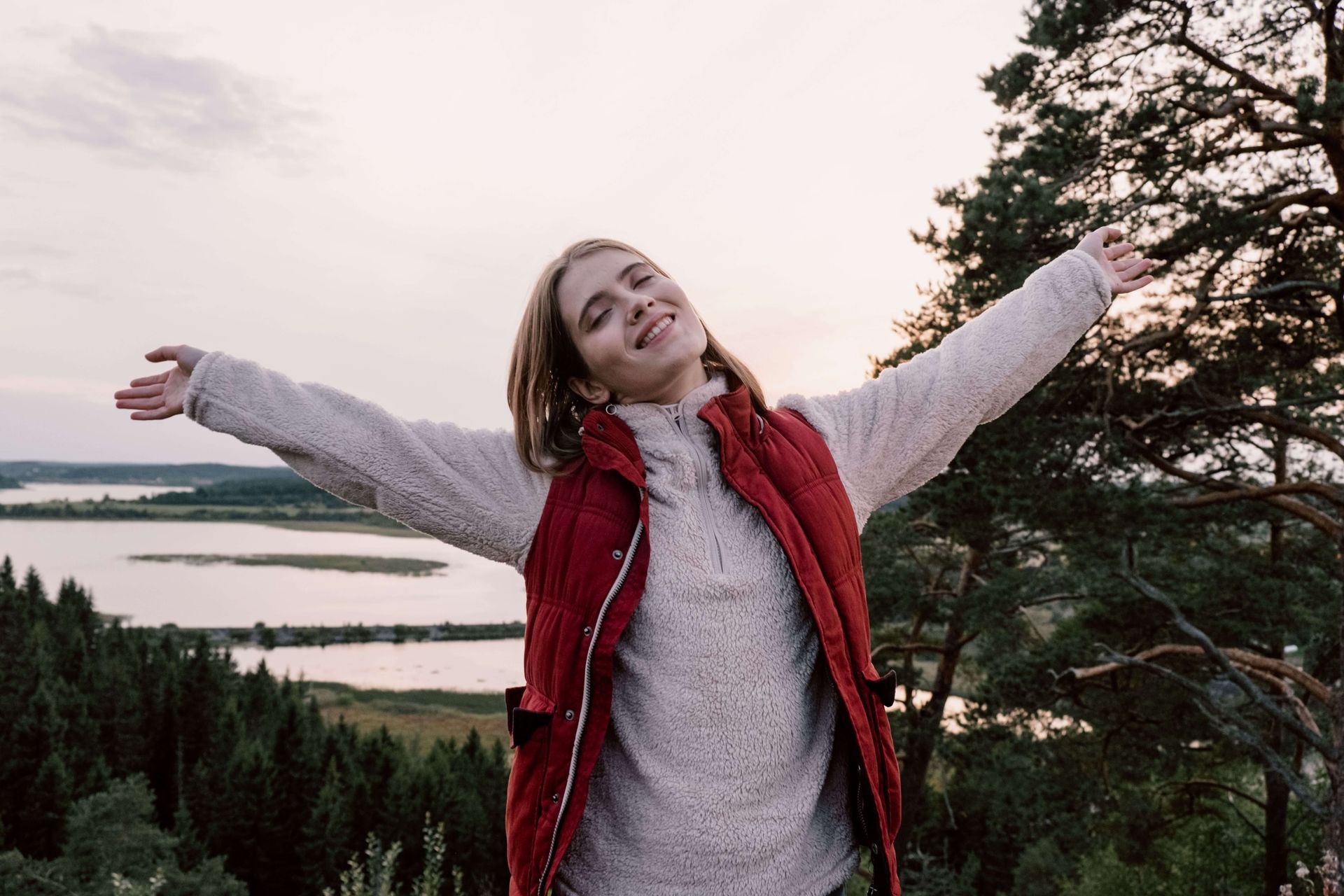 Woman outdoors with her arms outstretched and a joyful expression, symbolizing greater calm and well-being supported through anxiety therapy in Omaha, NE | anxiety therapy omaha ne - anxiety and adhd therapy omaha ne - anxiety therapist omaha ne - elkhorn - gretna - bennington - blair - millard - wahoo - waverly - papillion