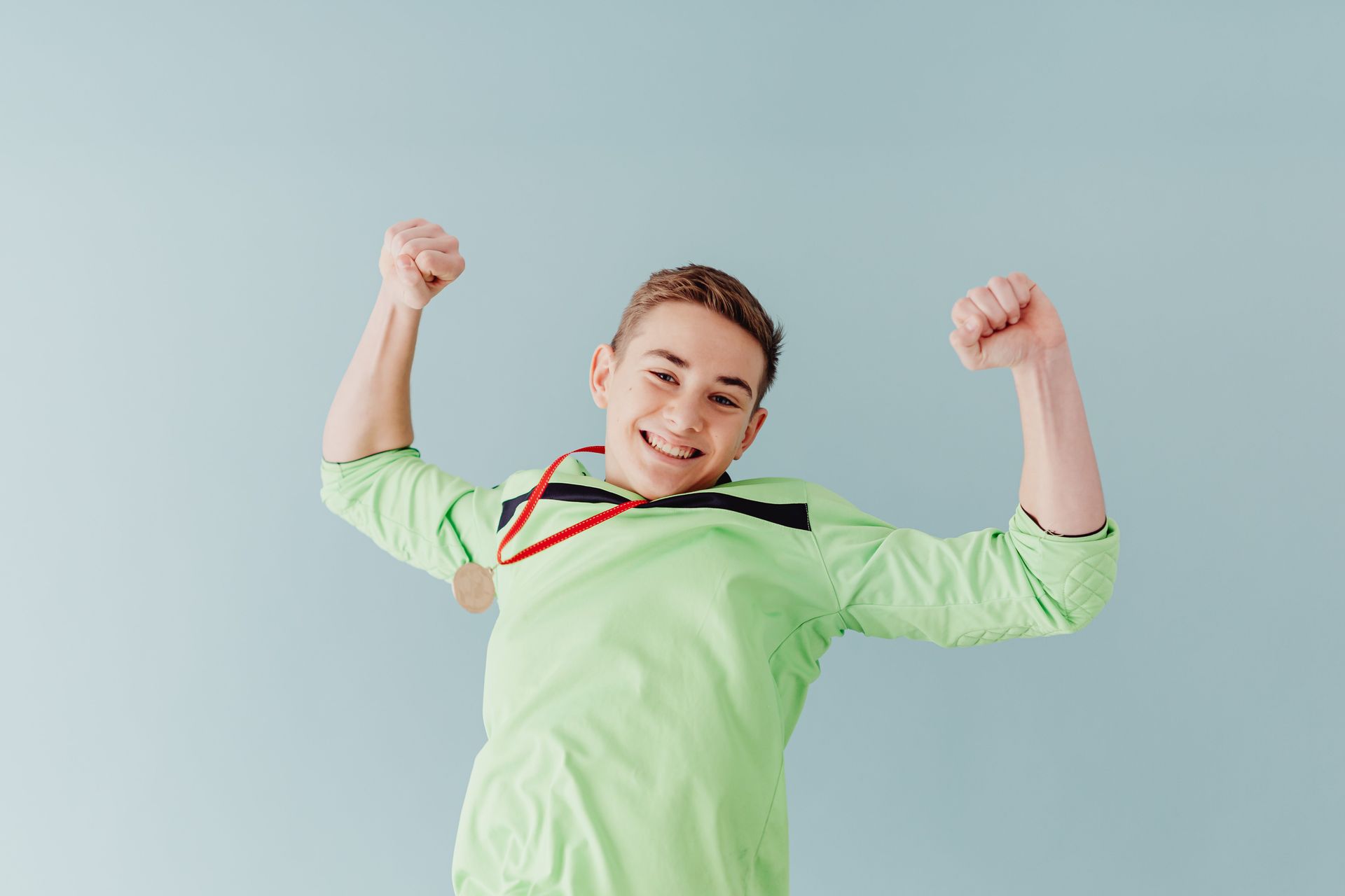 Happy boy wearing a medal around his neck, symbolizing pride, confidence, and positive progress supported through anxiety and athletes in Omaha, NE | anxiety and athletes omaha ne - anxiety in sports omaha ne - anxiety therapy omaha ne - elkhorn - gretna - bennington - blair - millard - wahoo - waverly - papillion