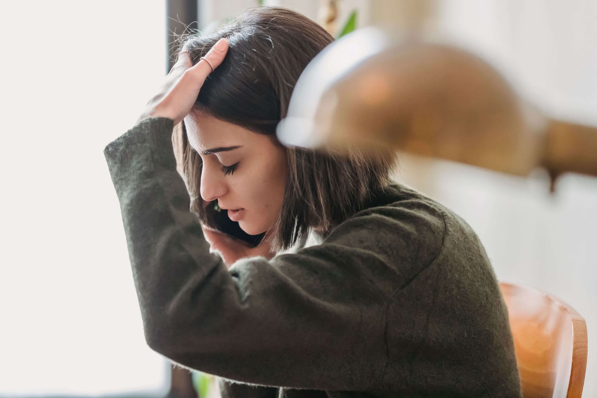 Woman talking on the phone while appearing anxious, representing the emotional overwhelm addressed through therapy for anxiety and grief in Omaha, NE | therapy for anxiety and grief omaha ne - therapy for grief and anxiety omaha ne - therapy for anxiety omaha ne - elkhorn - gretna - bennington - blair - millard - wahoo - waverly - papillion
