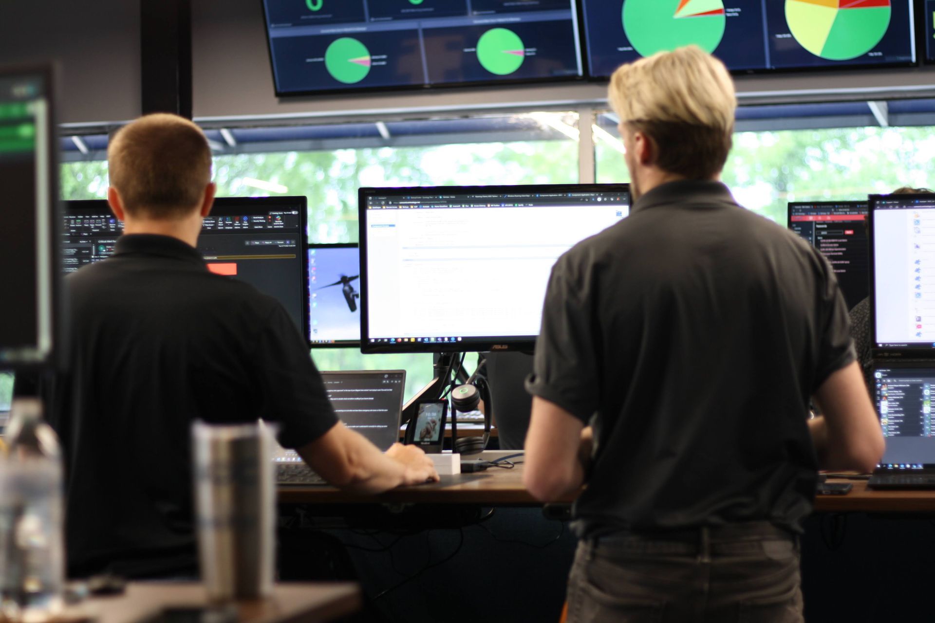 Two men looking at a computer monitor with a green circle on it