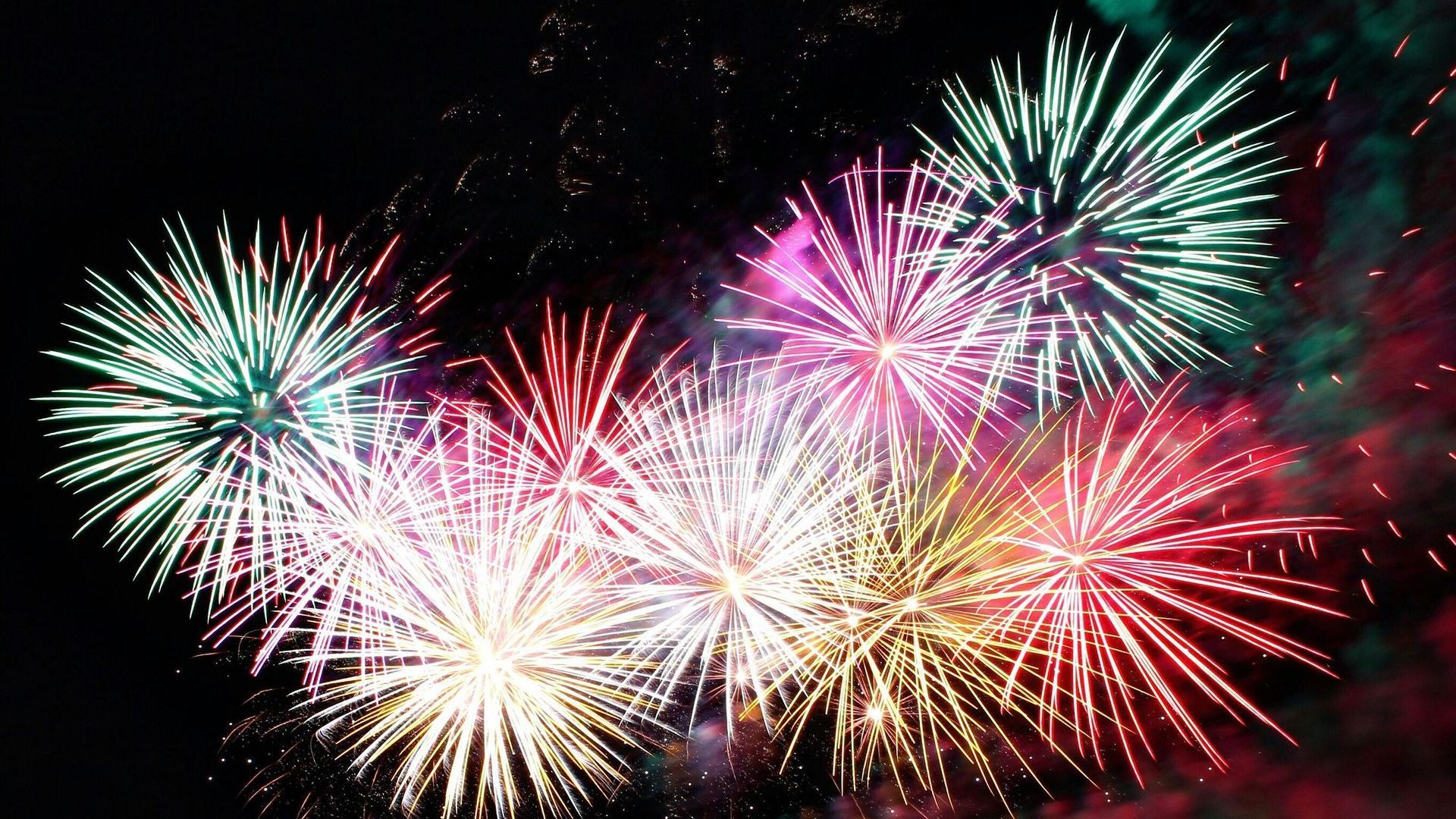 A bunch of fireworks are going off in the night sky