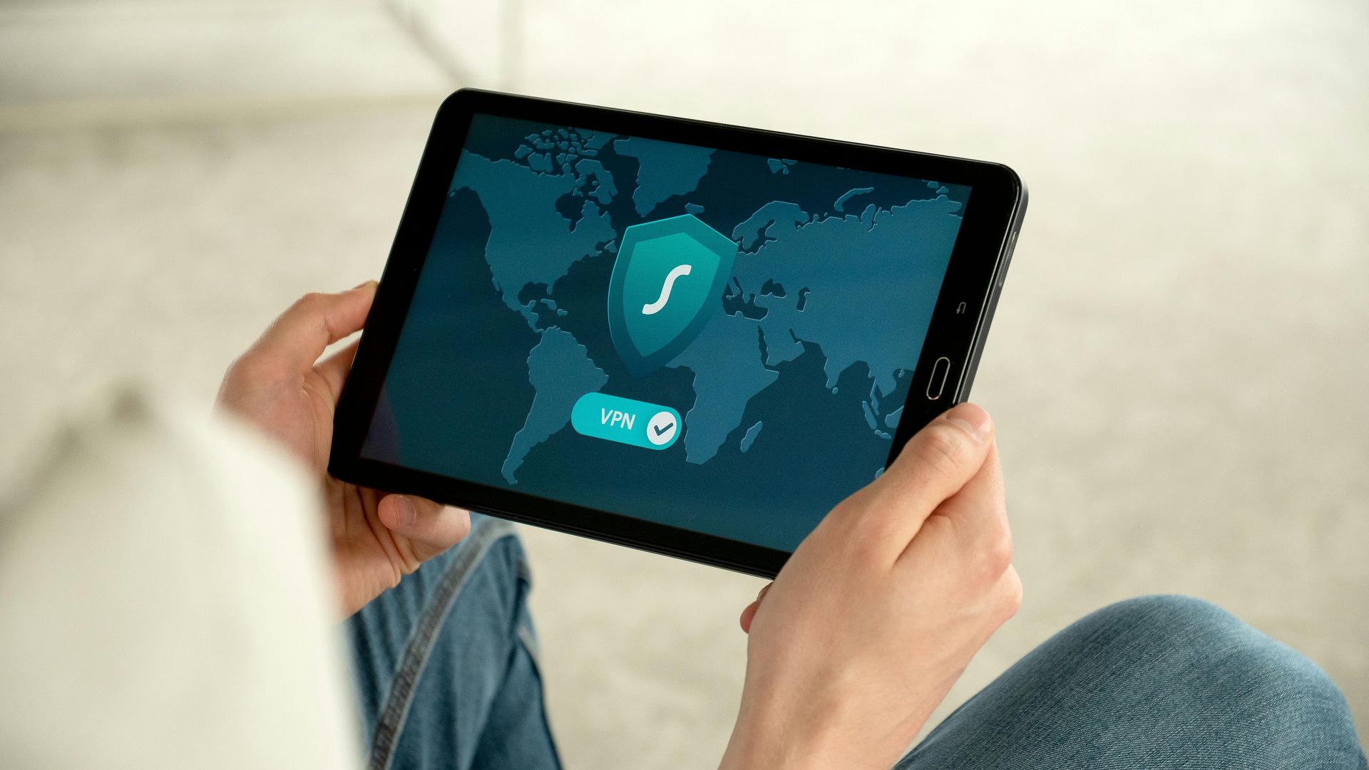 A person is holding a tablet with a map of the world on it