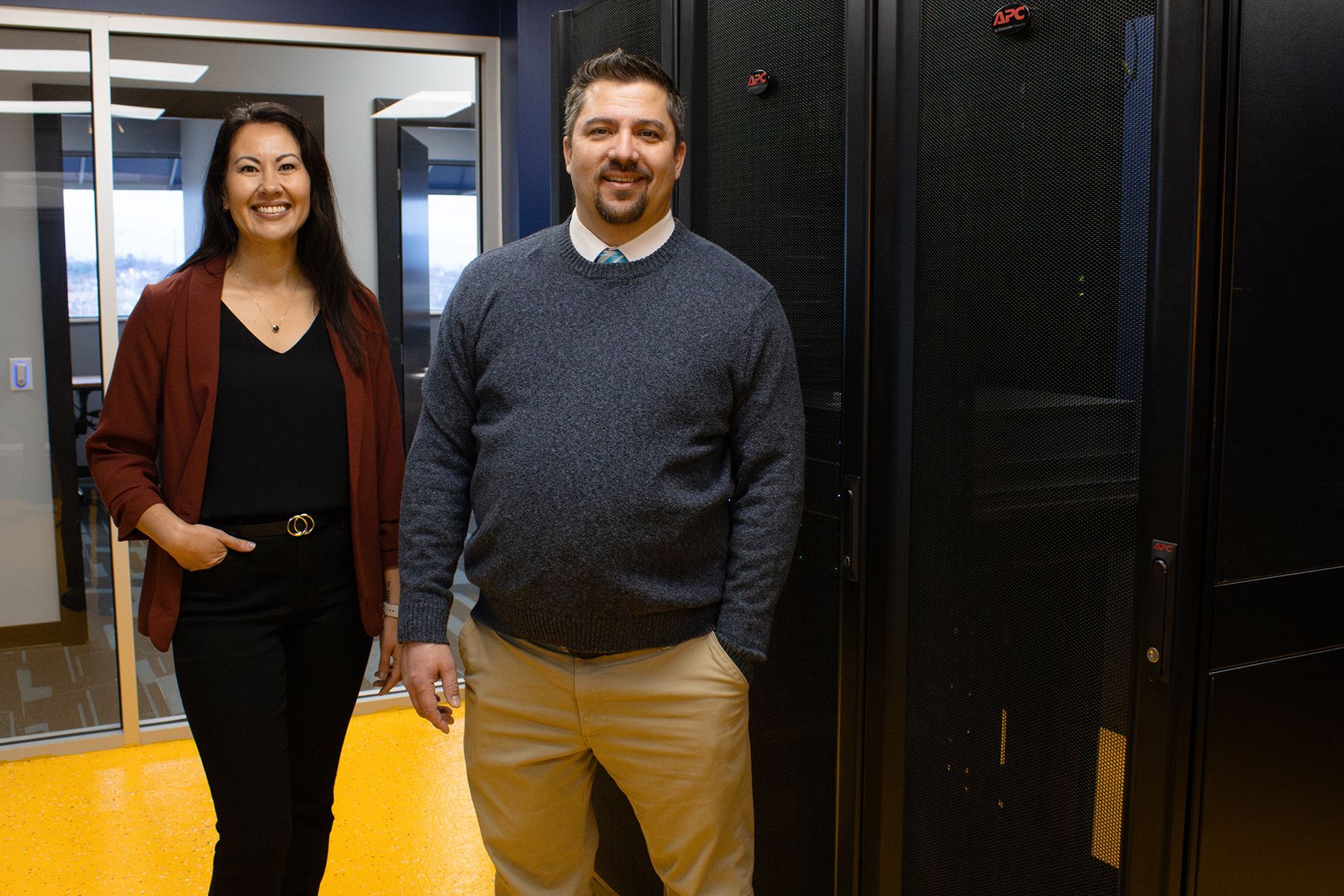A man and a woman standing next to each other in a server room
