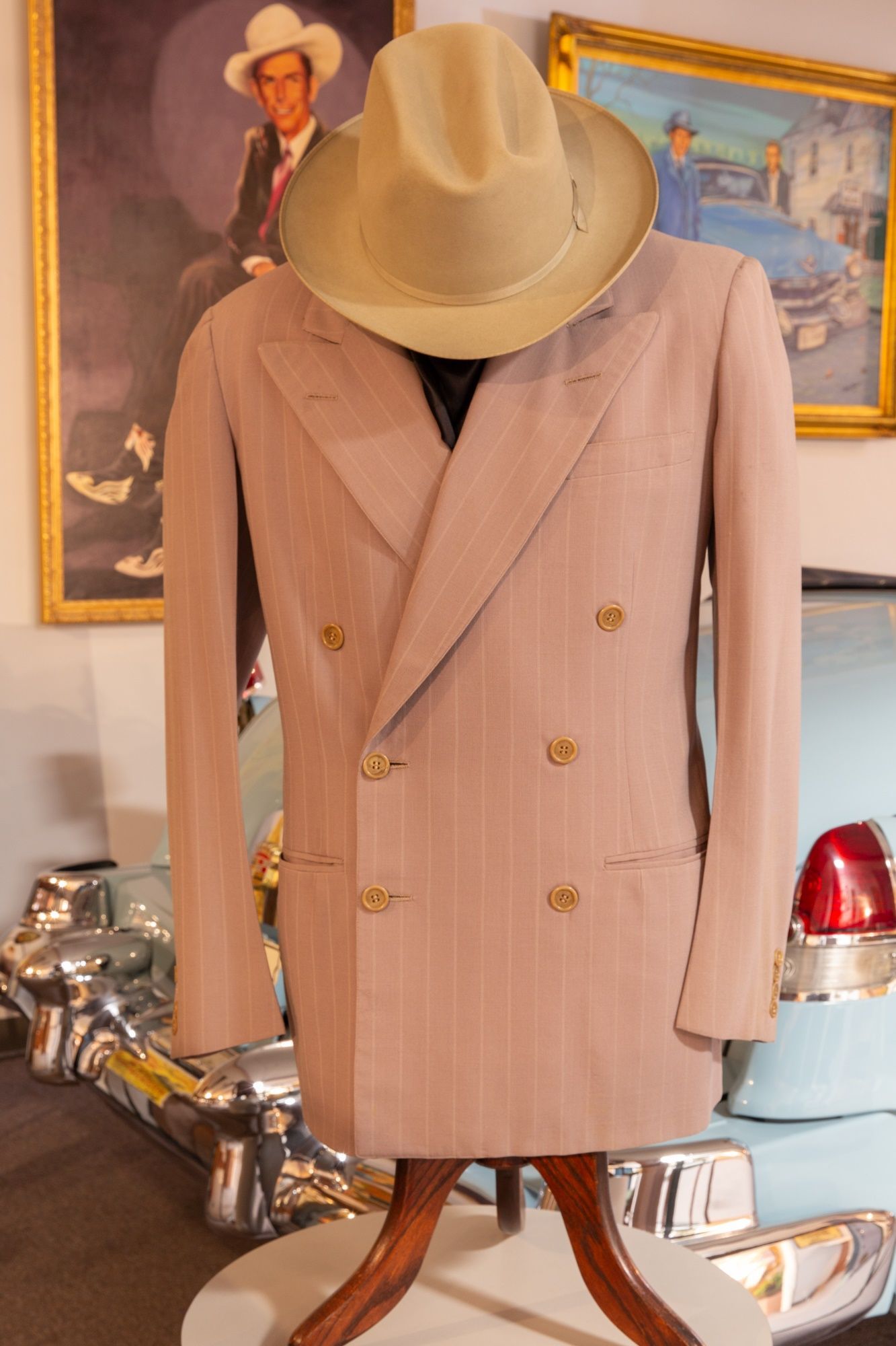 A cowboy hat is sitting on top of a suit on a mannequin.