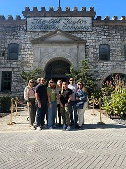 A group of people are posing for a picture in front of a brick building.