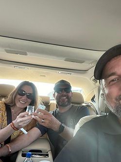 A group of people are sitting in the back seat of a car.