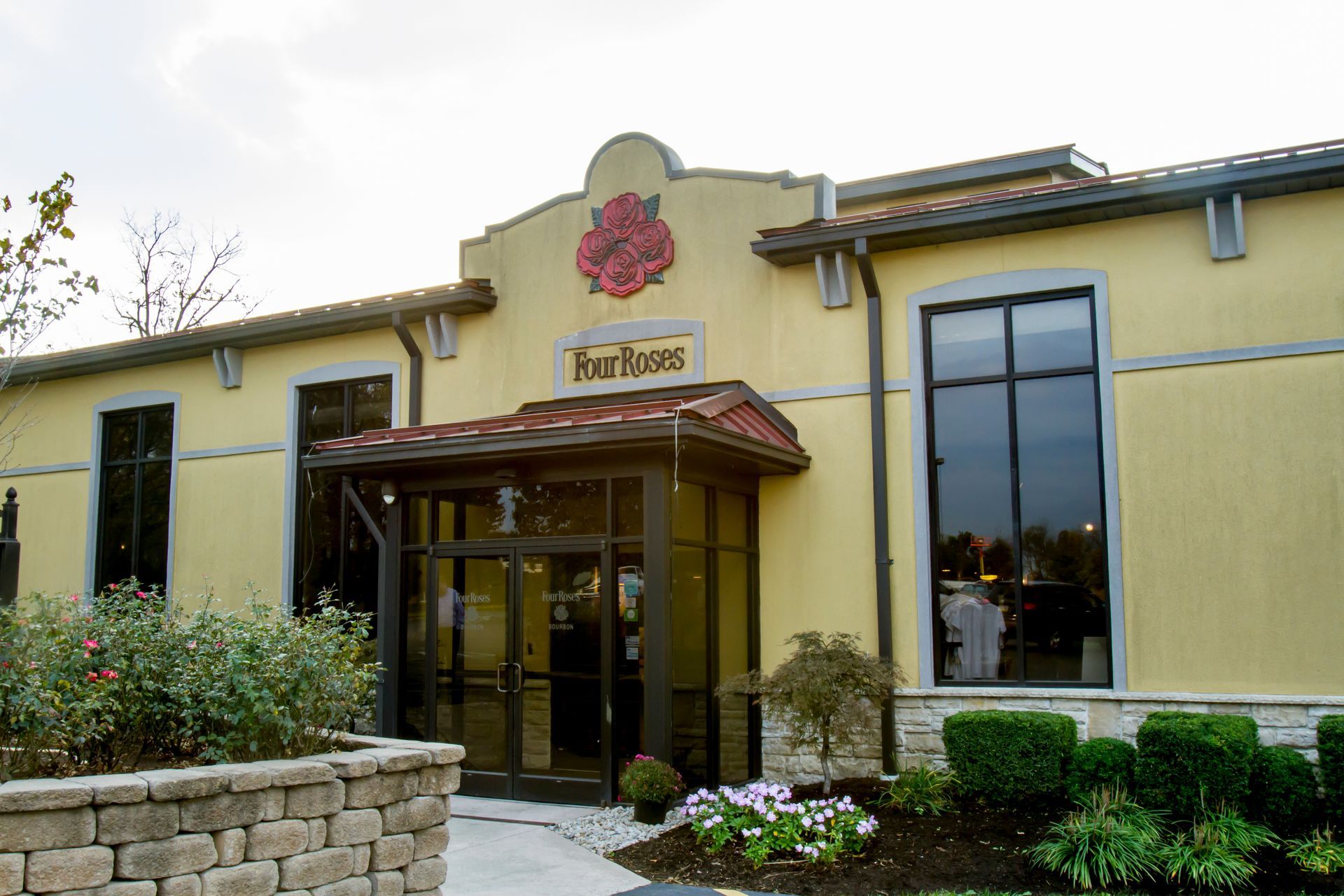 A yellow building with a red rose on the front of it