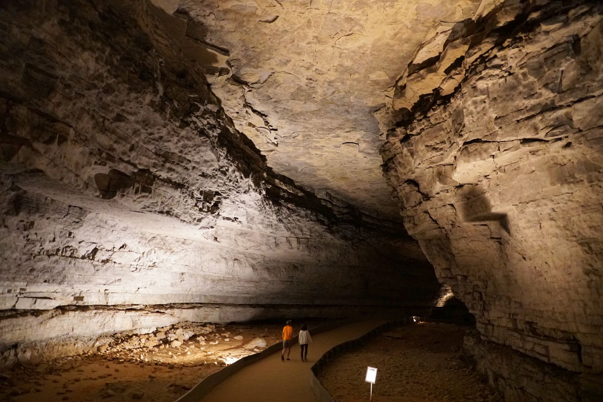 A group of people are walking through a cave.