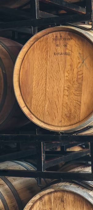 A stack of wooden wine barrels sitting on top of each other in a wine cellar.