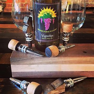 A bottle of vignoles wine sits on a wooden cutting board