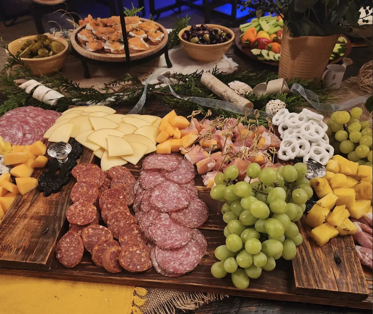 A charcuterie spread with cheeses, cured meats, grapes, and pretzels prepared for an in-cottage dinner