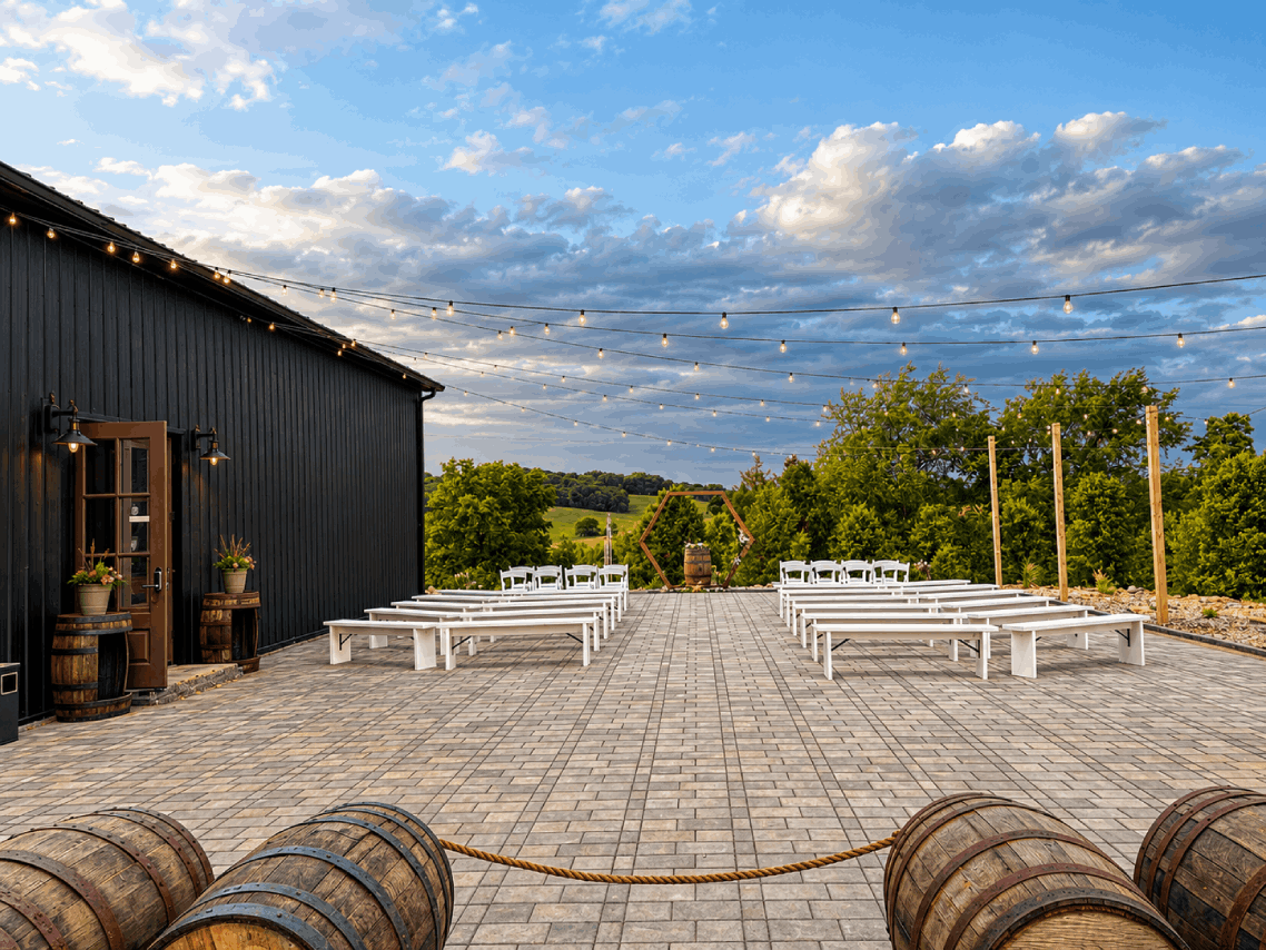 Bourbon Barrel Cottages outdoor wedding ceremony with white bench aisle, hexagon arch, and scenic countryside views