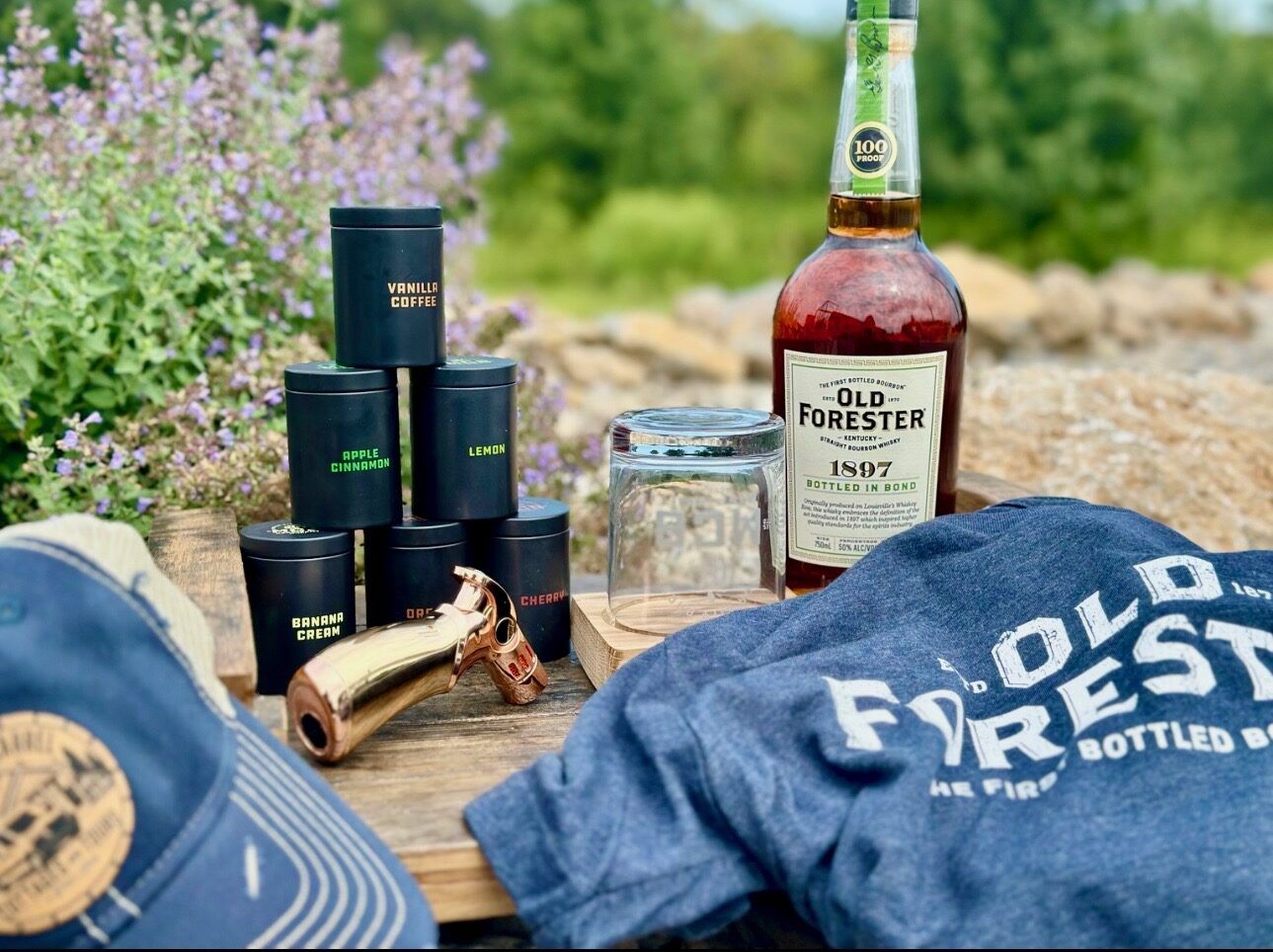 Flavored smoking wood chip tins, a cocktail smoking torch, and an Old Forester bottle styled with a bourbon hat and t-shirt