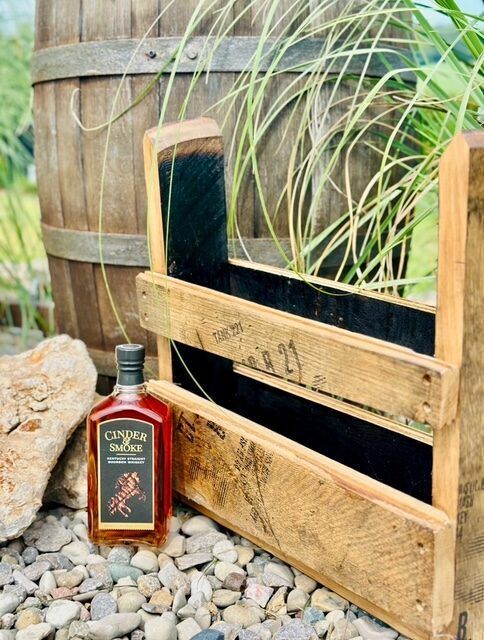 Barrel stave multipurpose accessory rack shown outdoors with a bourbon tasting flight board, angle two