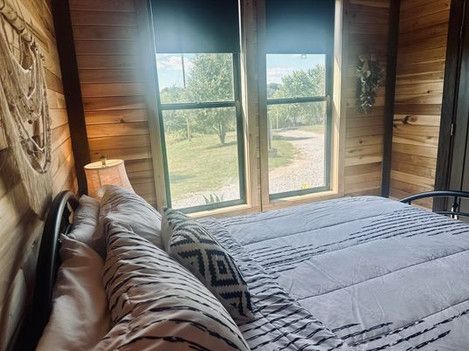 A bedroom with a king size bed and two windows.
