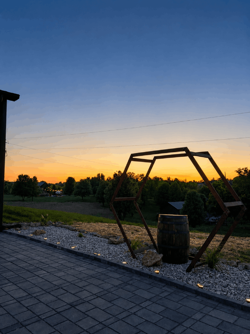 Rustic metal hexagon wedding arch with bourbon barrel at Bourbon Barrel Cottages at sunset